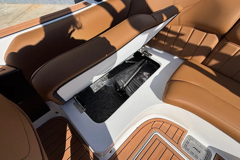 Slide: The Image of 2026 MB SPORTS F21 Classic boat interior with open storage compartment and brown seating. - 45
