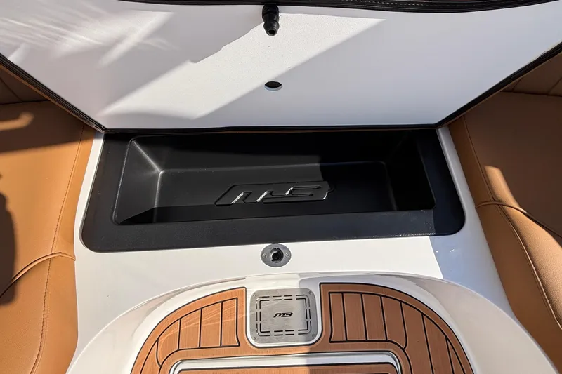 Slide: The Image of 2026 MB SPORTS F21 Classic boat interior storage compartment with logo and teak-style flooring. - 46