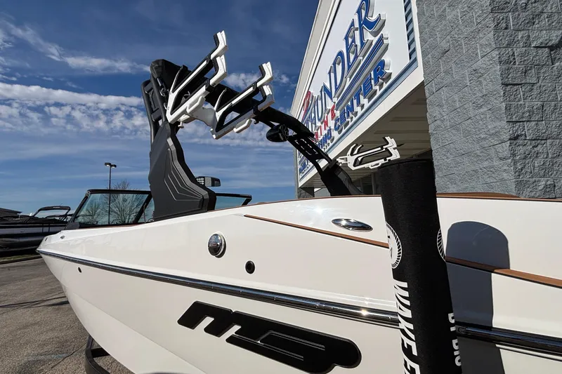 Slide: The Image of 2026 MB SPORTS F21 Classic boat at dealership, showcasing sleek design and wakeboard rack. - 51