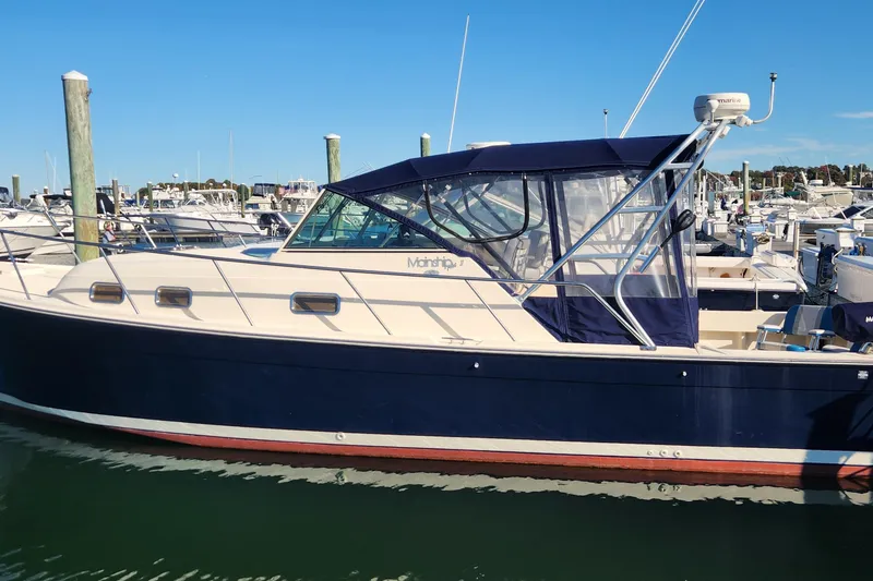The Image of 2003 Mainship Pilot 30-II boat docked at marina, featuring blue and white exterior. - 0