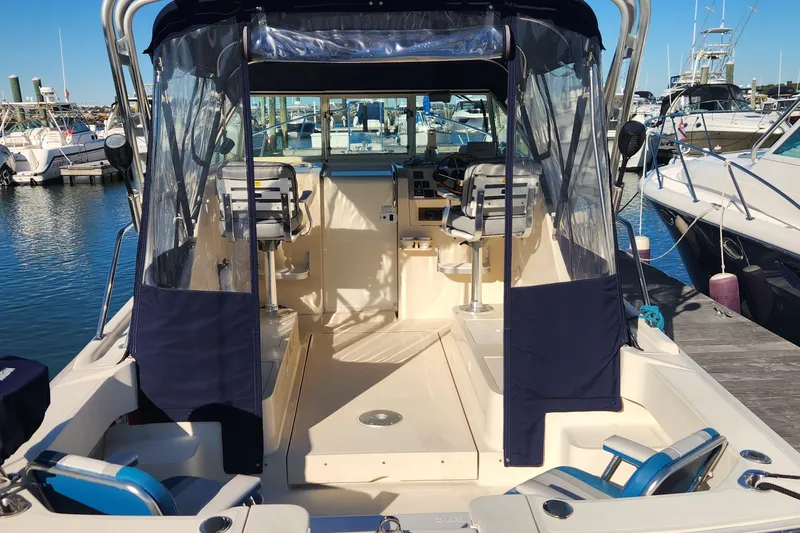 Slide: The Image of 2003 Mainship Pilot 30-II boat interior at marina, featuring helm and seating area. - 2