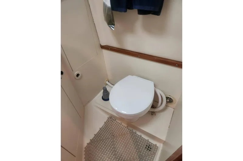 Slide: The Image of 2003 Mainship Pilot 30-II boat bathroom with toilet and mat. - 20