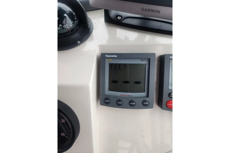 Slide: The Image of Raymarine depth gauge on 2003 Mainship Pilot 30-II boat dashboard with Garmin device. - 21