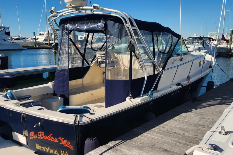 Slide: The Image of 2003 Mainship Pilot 30-II docked at marina, featuring blue canopy and sleek design. - 3