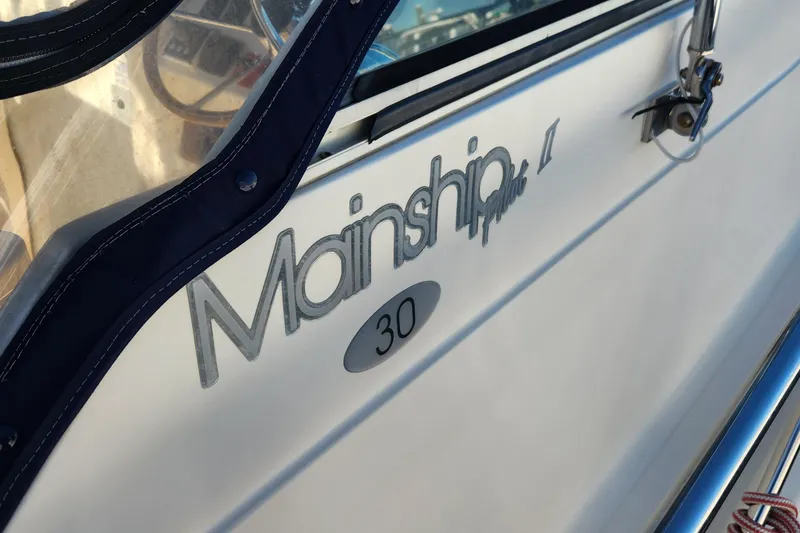 Slide: The Image of 2003 Mainship Pilot 30-II boat nameplate detail with window and railing. - 7