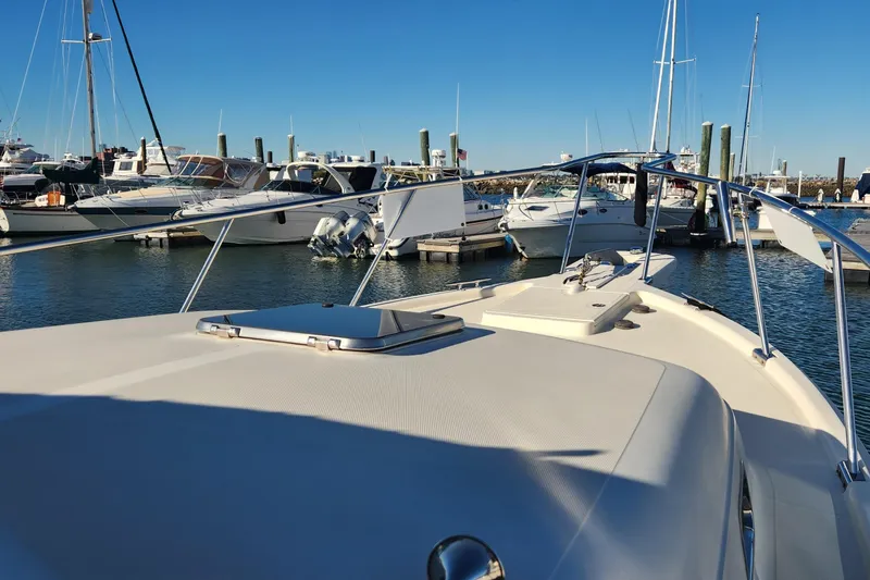Slide: The Image of 2003 Mainship Pilot 30-II docked in a marina with other boats under clear blue sky. - 8