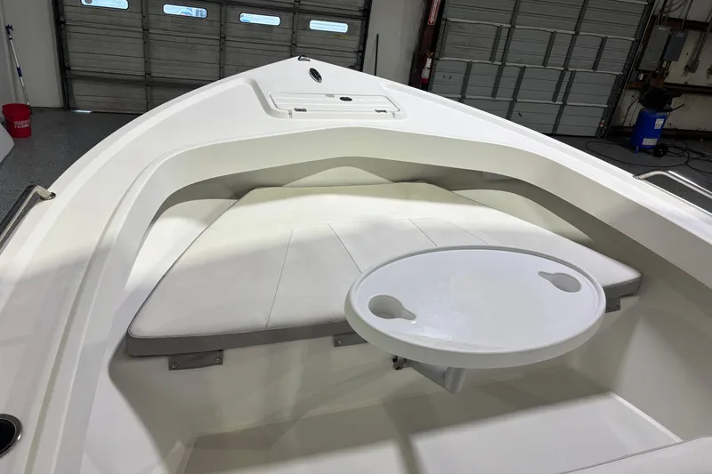 Slide: The Image of 2020 Parker 2100 Center Console boat interior with cushioned seating and round table. - 13