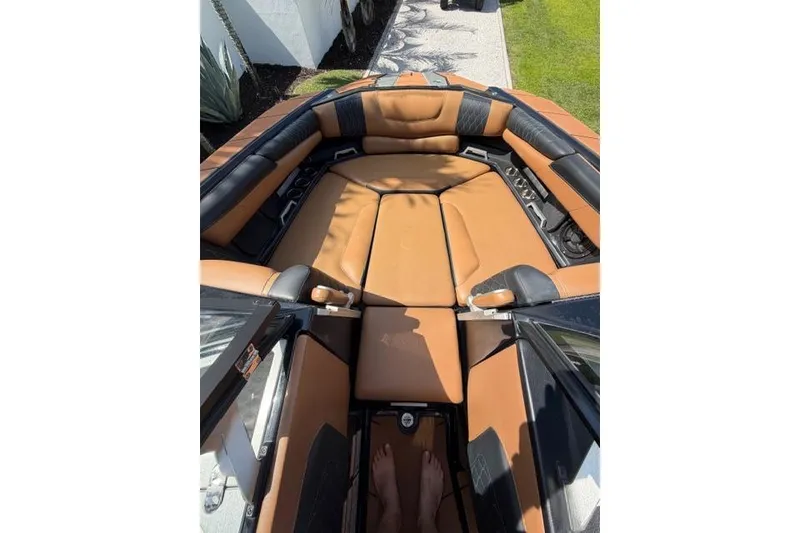 Slide: The Image of Interior view of a 2021 Malibu M240 boat with tan and black seating. - 11