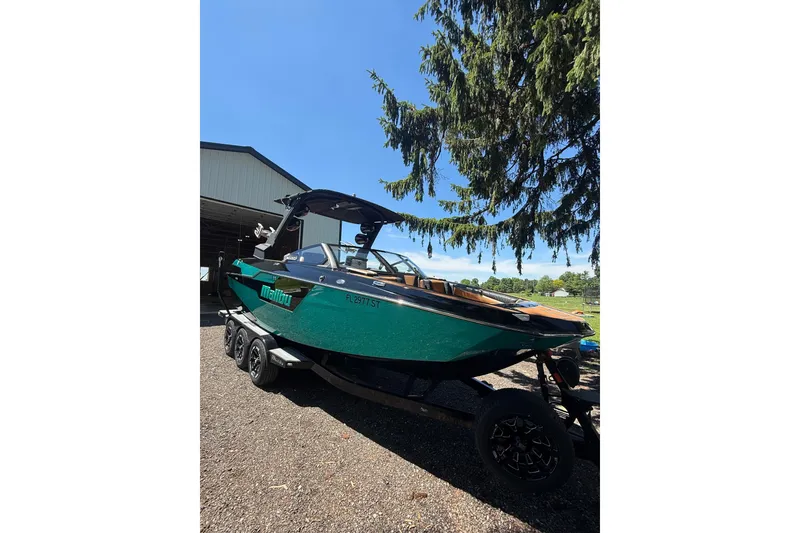 Slide: The Image of 2021 Malibu M240 boat on trailer under a tree, sunny day. - 18