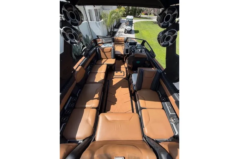 Slide: The Image of Interior of 2021 Malibu M240 boat with tan leather seating and large speakers. - 7