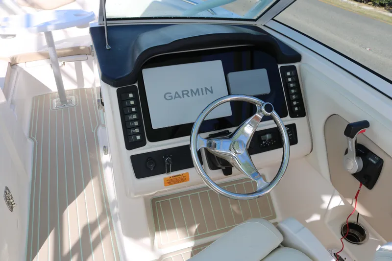 Slide: The Image of 2019 Robalo R247 Dual Console helm with Garmin display and steering wheel. - 10