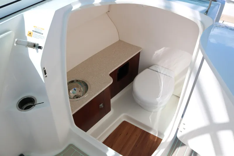 Slide: The Image of 2019 Robalo R247 Dual Console boat interior with toilet and sink. - 12