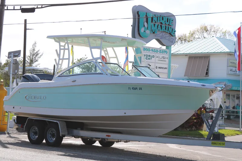 Slide: The Image of 2019 Robalo R247 Dual Console boat on trailer at Unique Marine dealership. - 3
