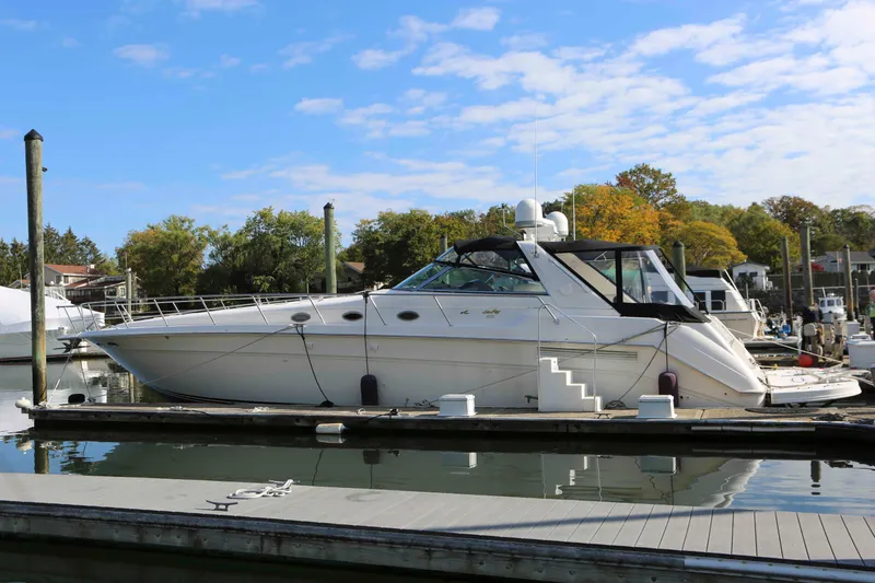 The Image of 1999 Sea Ray 500 Sundancer yacht docked at marina under blue sky. - 0