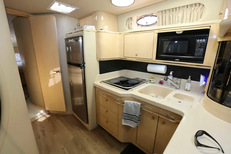 Slide: The Image of 1999 Sea Ray 500 Sundancer yacht kitchen with modern appliances and sleek cabinetry. - 13
