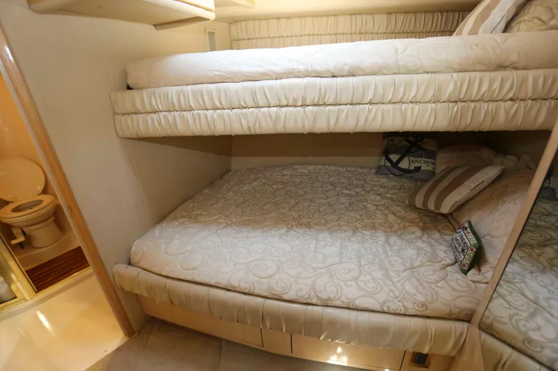 Slide: The Image of 1999 Sea Ray 500 Sundancer cabin with bunk beds and adjacent bathroom. - 19