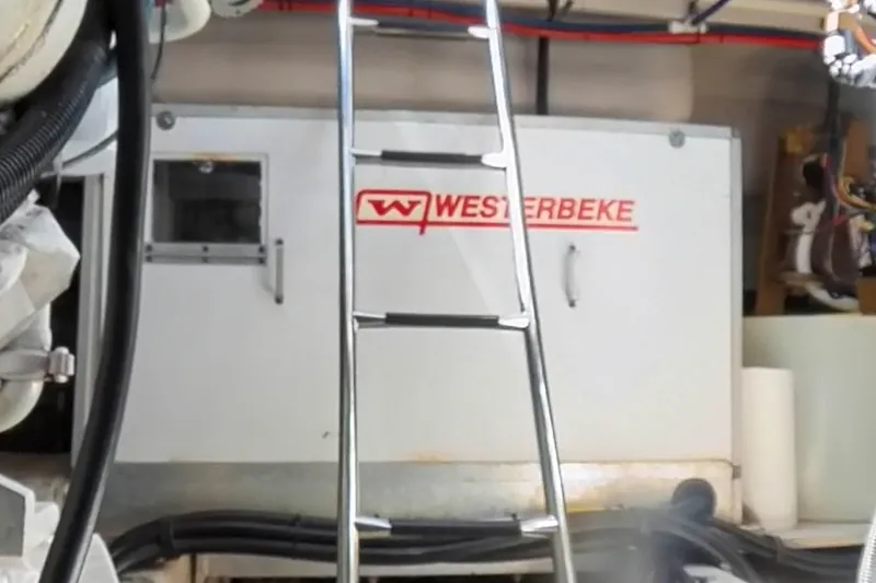 Slide: The Image of Engine room of 1999 Sea Ray 500 Sundancer with Westerbeke generator and ladder. - 28