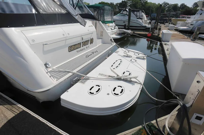 Slide: The Image of 1999 Sea Ray 500 Sundancer docked at marina, rear view with swim platform. - 4