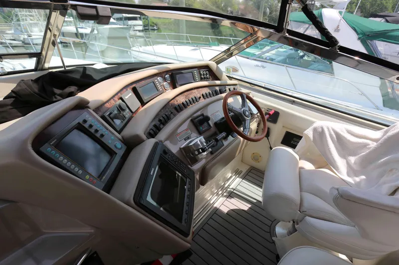 Slide: The Image of 1999 Sea Ray 500 Sundancer helm with advanced navigation controls and luxurious seating. - 6