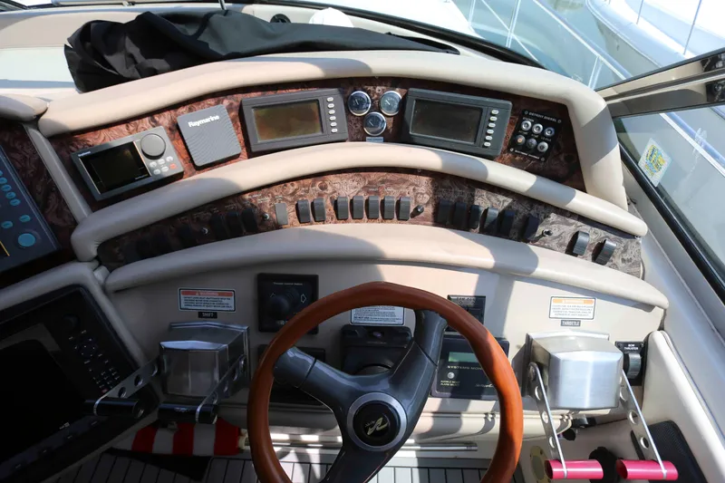 Slide: The Image of Cockpit of 1999 Sea Ray 500 Sundancer with navigation instruments and wooden steering wheel. - 8