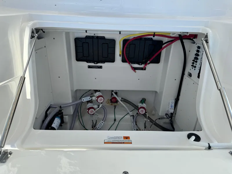 Slide: The Image of 2025 Robalo R246 CAYMAN boat compartment with wiring and control systems. - 18