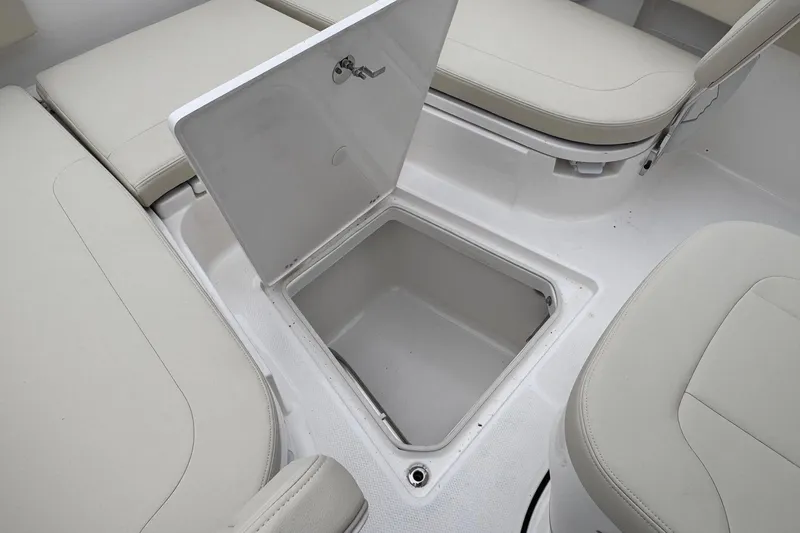 Slide: The Image of 2026 Robalo 266 Cayman boat storage compartment with open hatch and cushioned seating. - 15