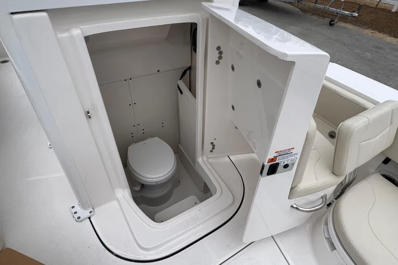 Slide: The Image of 2026 Robalo 266 Cayman boat interior with compact marine toilet. - 17