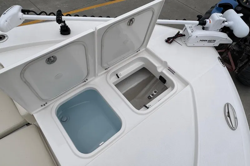 Slide: The Image of 2026 Robalo 266 Cayman boat deck with open storage compartments and Minn Kota trolling motor. - 21