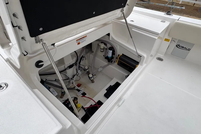 Slide: The Image of Open storage compartment of 2026 Robalo 266 Cayman boat, showcasing internal components. - 24