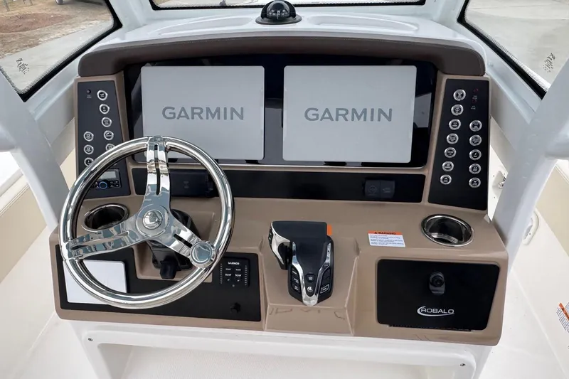 Slide: The Image of 2026 Robalo 266 Cayman helm with dual Garmin displays and sleek steering wheel. - 6