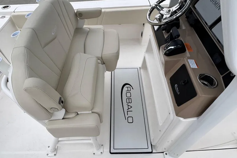 Slide: The Image of 2026 Robalo 266 Cayman boat interior with beige seating and steering console. - 8