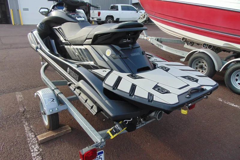 Slide: The Image of 2023 Yamaha WaveRunner FX SVHO on trailer, parked near a red boat. - 6