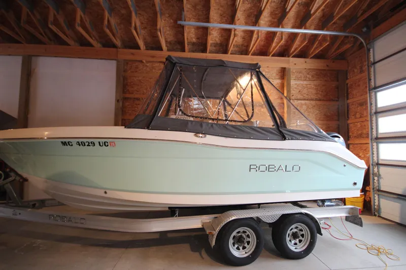 The Image of 2016 Robalo R200 Center Console boat on trailer in garage. - 1