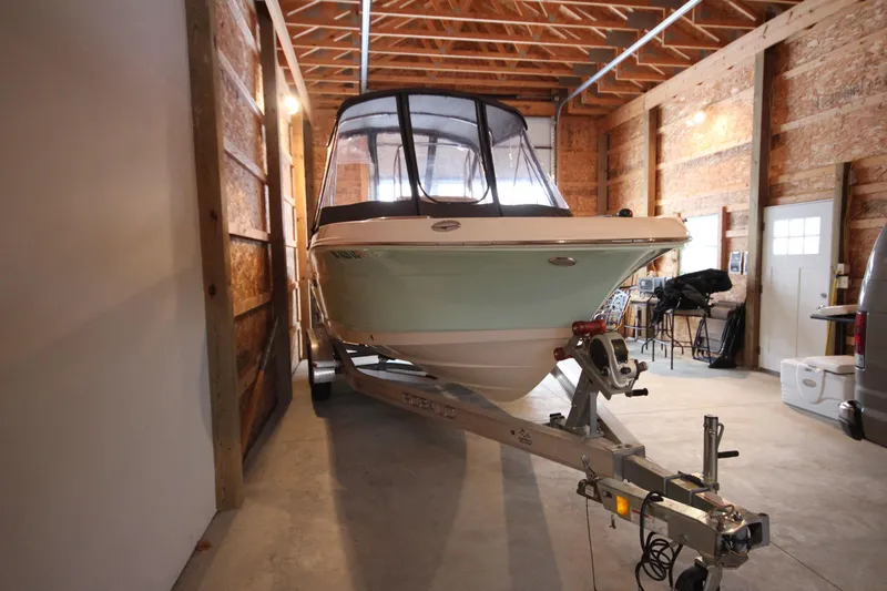 Slide: The Image of 2016 Robalo R200 Center Console boat on trailer in wooden garage. - 2