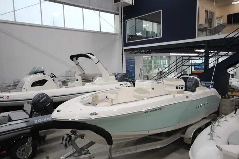 Slide: The Image of 2016 Robalo R200 Center Console boat displayed in a showroom with other vessels. - 24