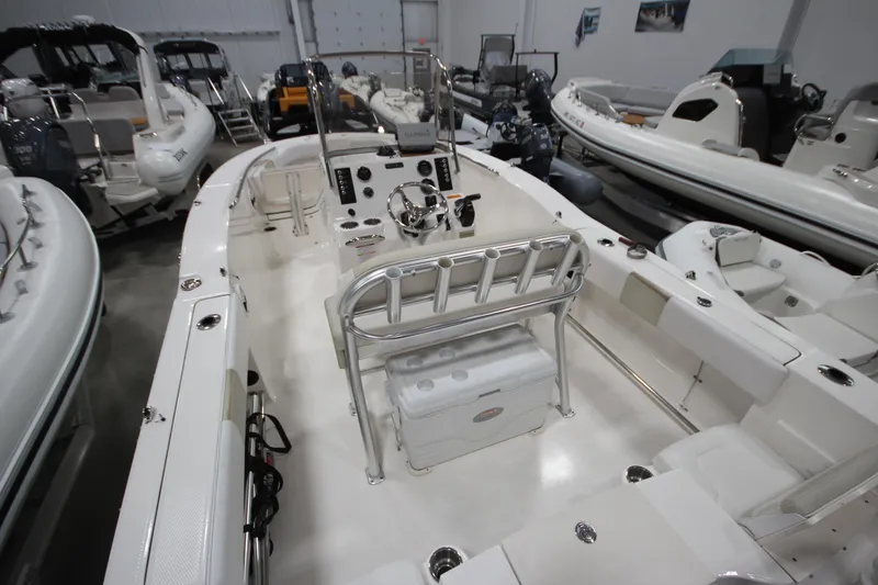Slide: The Image of 2016 Robalo R200 Center Console boat interior in showroom with multiple vessels. - 30
