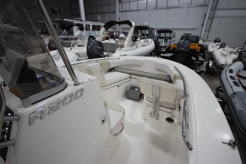 Slide: The Image of 2016 Robalo R200 Center Console boat in showroom, featuring spacious seating and sleek design. - 37