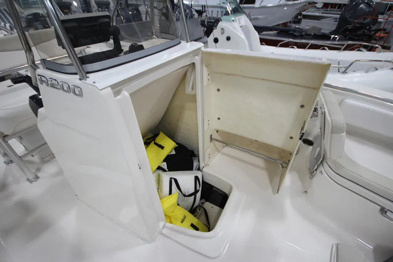 Slide: The Image of 2016 Robalo R200 Center Console boat storage compartment with life jackets. - 39