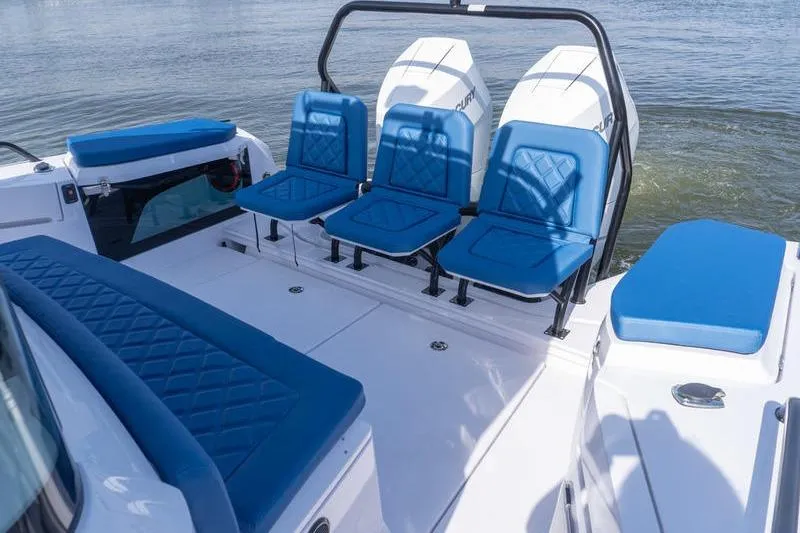 Slide: The Image of 2026 Axopar 37 XC Cross Cabin with blue seating and twin engines on water. - 5