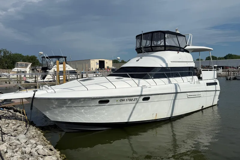 The Image of 1992 Silverton 41 Motor Yacht docked at a marina under a cloudy sky. - 0