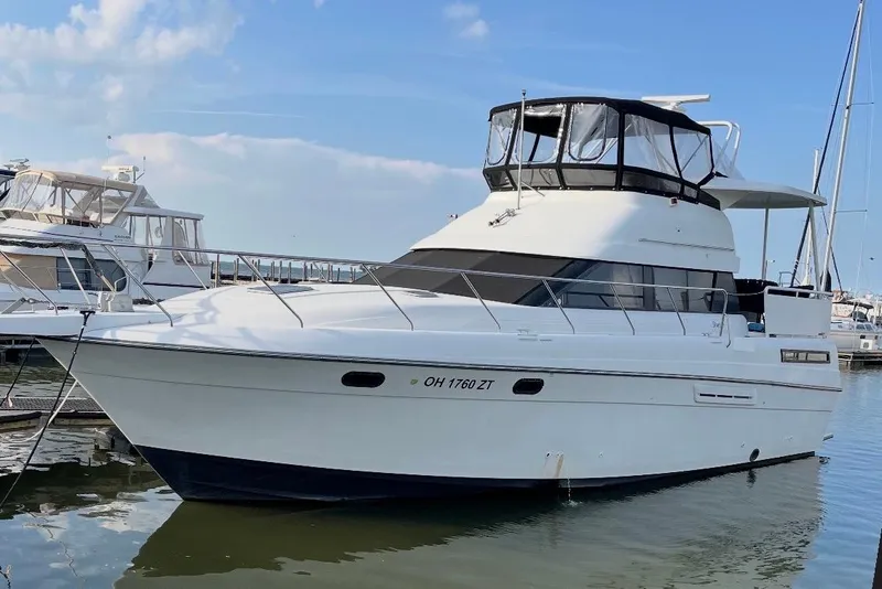 The Image of 1992 Silverton 41 Motor Yacht docked in marina under clear blue sky. - 1