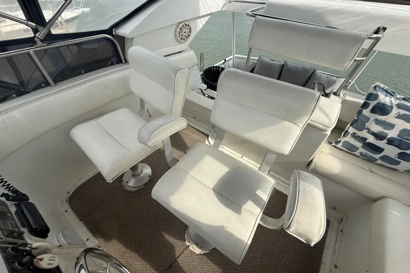 Slide: The Image of Captain's chairs on 1992 Silverton 41 Motor Yacht, featuring white upholstery and nautical decor. - 12