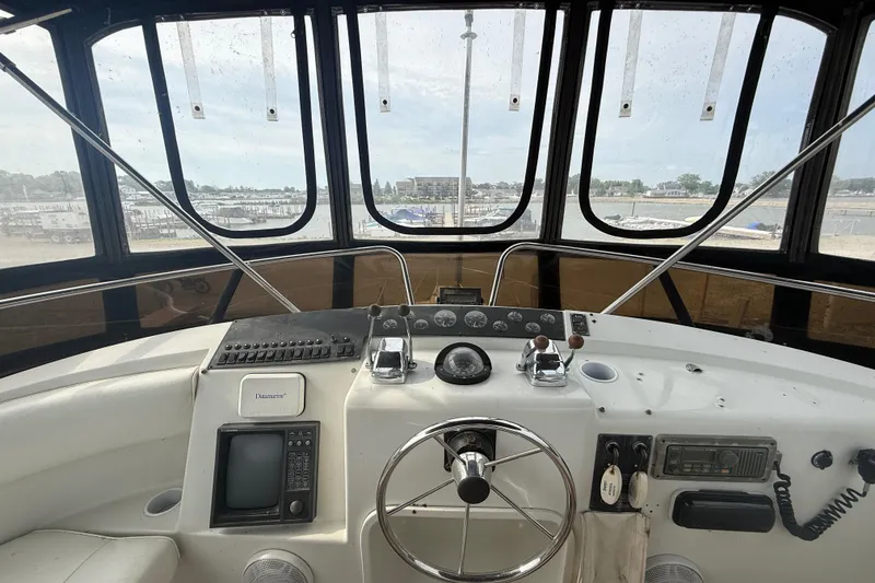 Slide: The Image of 1992 Silverton 41 Motor Yacht helm with steering wheel and navigation controls. - 13