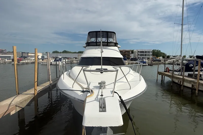 Slide: The Image of 1992 Silverton 41 Motor Yacht docked at marina under clear sky. - 2