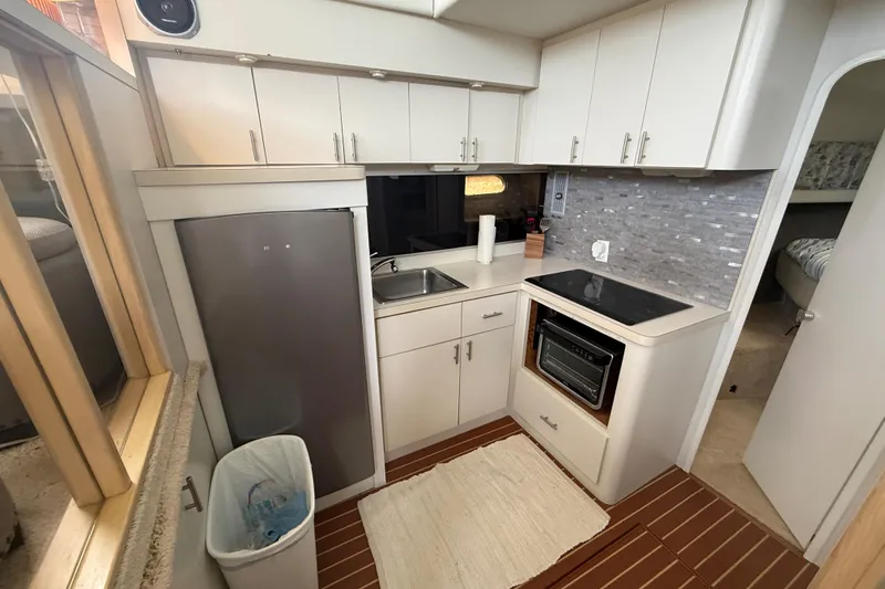 Slide: The Image of Compact kitchen in a 1992 Silverton 41 Motor Yacht with modern appliances and wood flooring. - 26