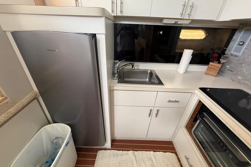 Slide: The Image of Compact kitchen area in a 1992 Silverton 41 Motor Yacht with sink, fridge, and oven. - 27