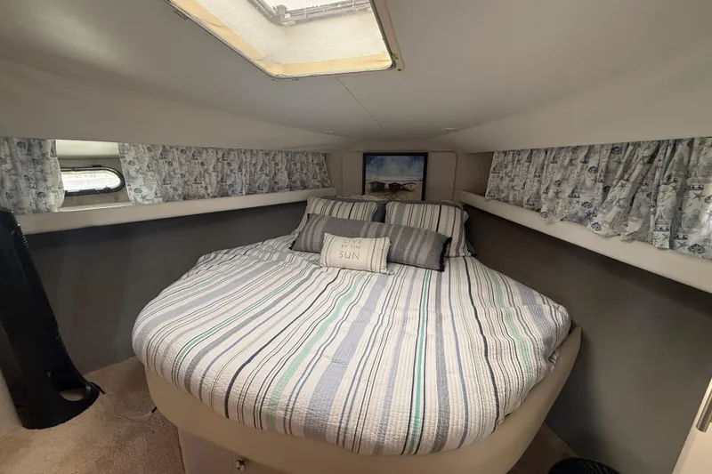 Slide: The Image of Cozy bedroom in 1992 Silverton 41 Motor Yacht with striped bedding and decorative pillows. - 32