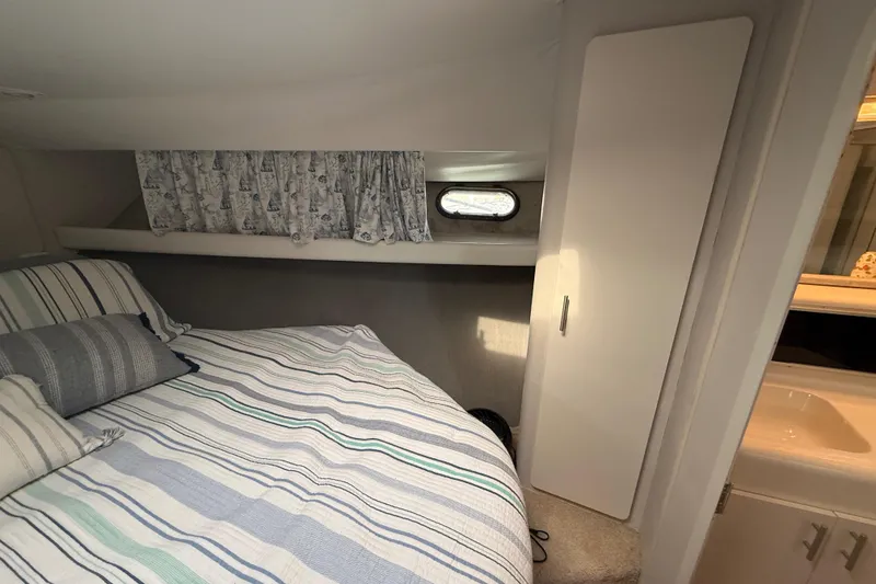 Slide: The Image of Cozy bedroom in 1992 Silverton 41 Motor Yacht with striped bedding and nautical curtains. - 35