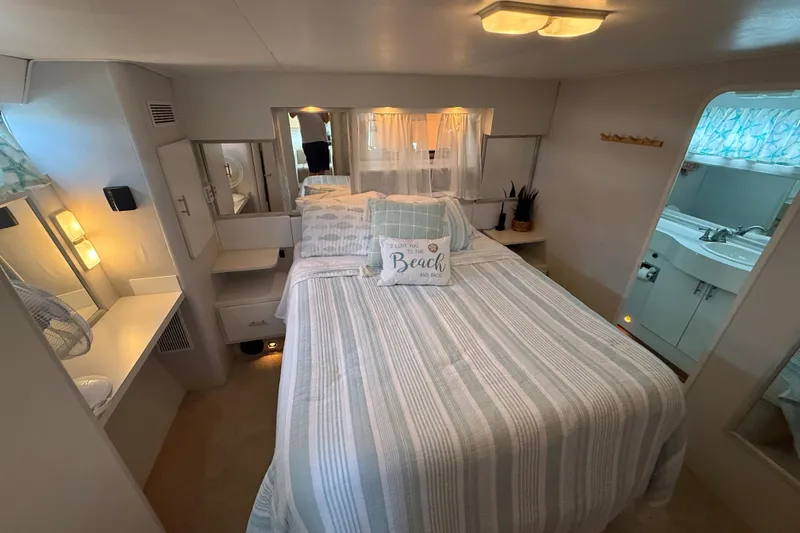 Slide: The Image of Cozy bedroom interior of 1992 Silverton 41 Motor Yacht with striped bedding and nautical decor. - 41