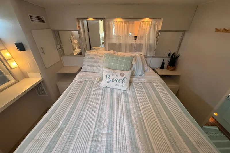 Slide: The Image of Cozy bedroom interior of 1992 Silverton 41 Motor Yacht with nautical decor and soft lighting. - 42